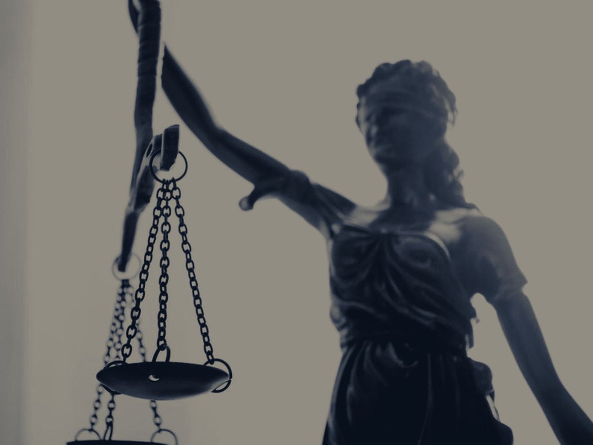 An attorney and a client shaking hands across a desk